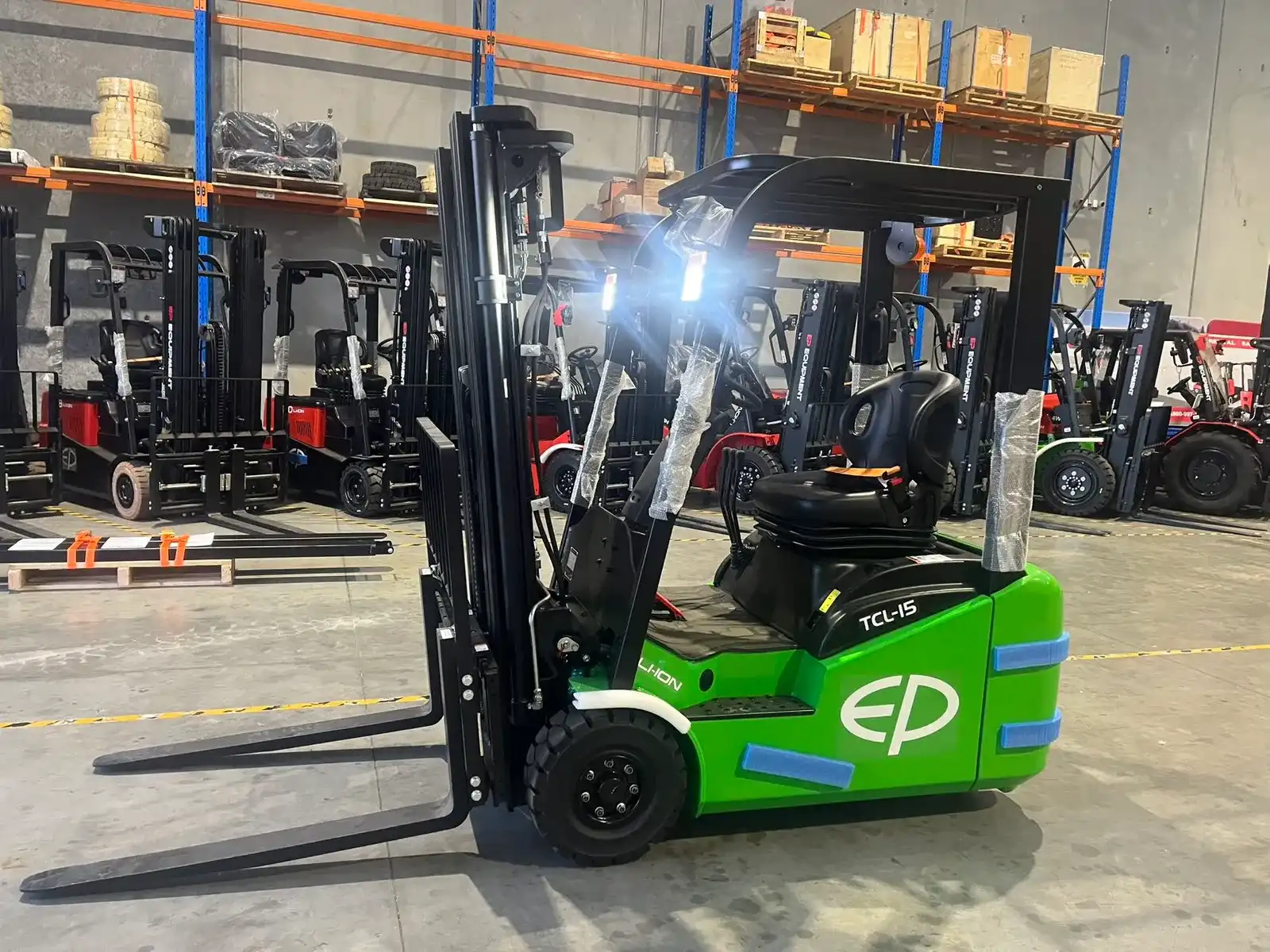 Thumbnail of EP Equipment TCL152 1.5T three-wheel lithium-ion electric forklift parked in the EPower Forklift warehouse alongside racking and other EP trucks