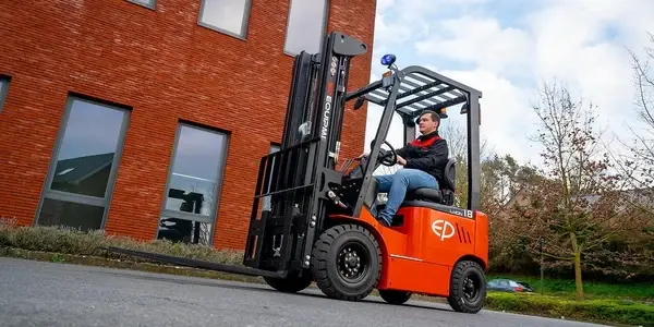 Operator driving EFL181 lithium electric forklift by EP Equipment outside a commercial building