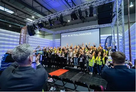 Group photo of EP Equipment and other attendees on stage after receiving the 2025 IFOY Best in Intralogistics award.