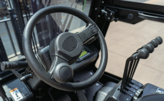 Close-up view of the CPD18TVL forklift steering wheel and control levers inside the operator cabin.