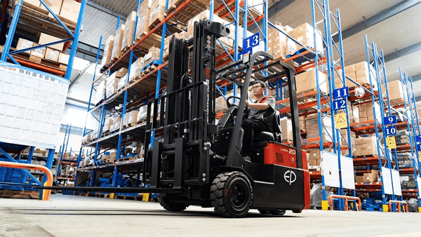 Operator driving EP Equipment CPD20TVL 2.0T three-wheel lithium-ion electric forklift in a warehouse, showcasing excellent maneuverability and efficiency for indoor material handling.