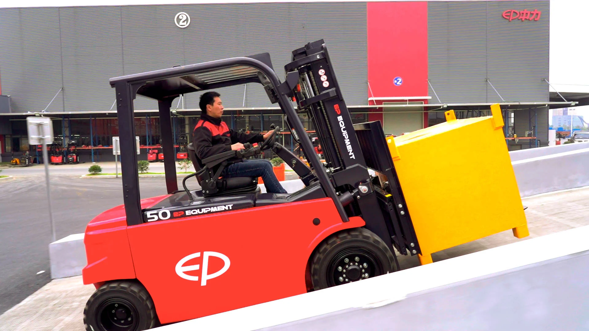 Operator driving EP Equipment CPD50L1 electric forklift outdoors while transporting goods, highlighting stability and smooth driving on flat surfaces.