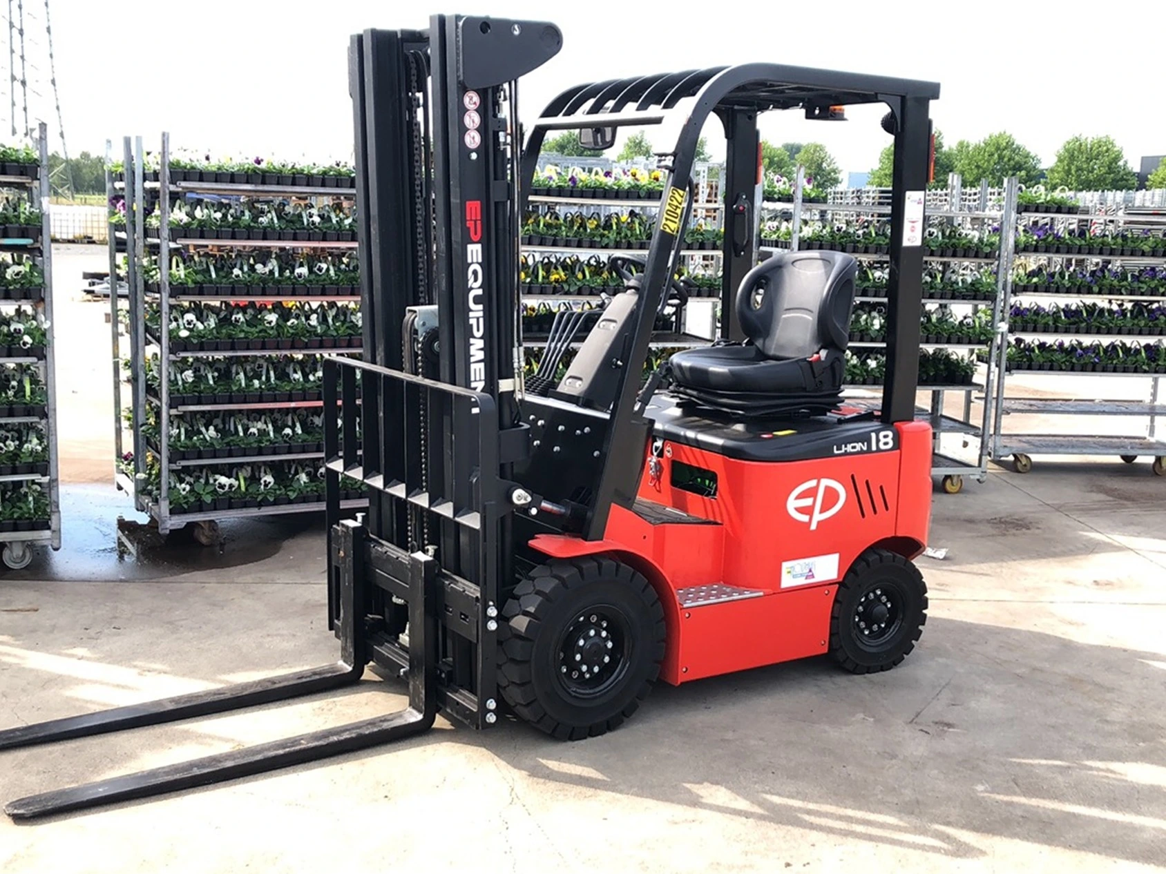 EFL181 lithium electric forklift by EP Equipment operating in outdoor nursery with plant racks in the background