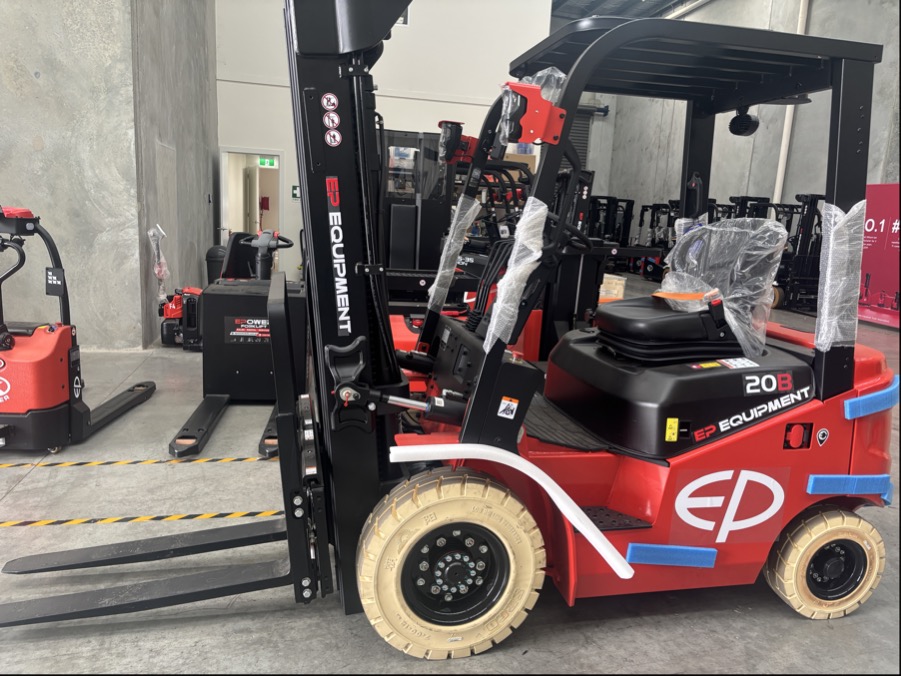 EFL203 four-wheel lithium-ion electric forklift by EP Equipment stored in warehouse with other forklifts