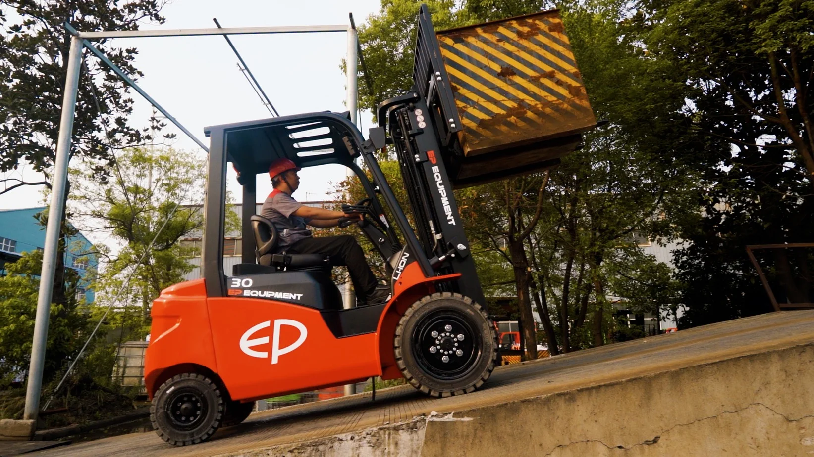 EFL303 lithium counterbalance forklift climbing ramp with loaded pallet, demonstrating high gradeability in outdoor setting