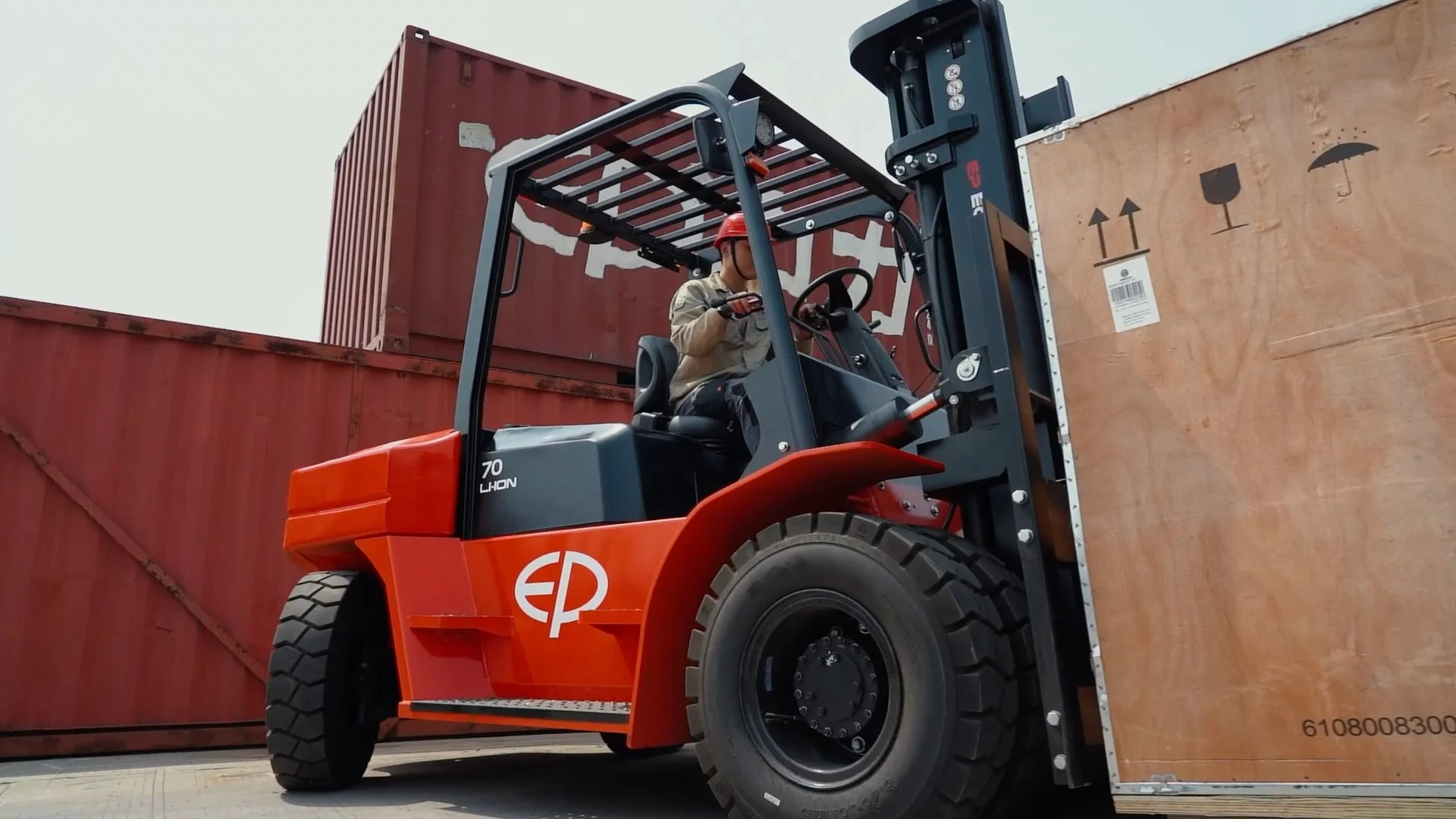 EP Equipment EFL702 heavy-duty electric forklift operating outdoors, lifting large wooden crates.