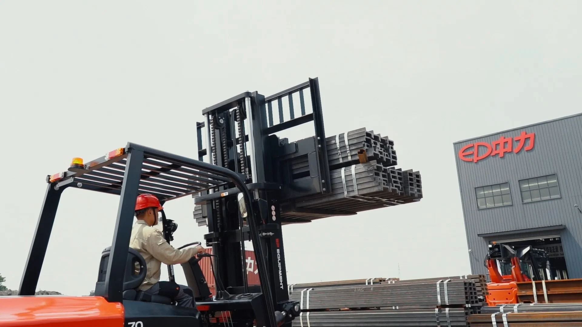 EP Equipment EFL703 HV electric forklift lifting steel materials in front of EP factory.
