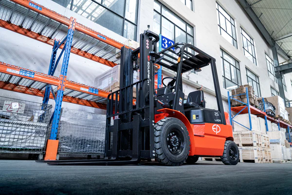 Operator using EP Equipment EFX252 lithium-ion electric forklift driving in a warehouse.