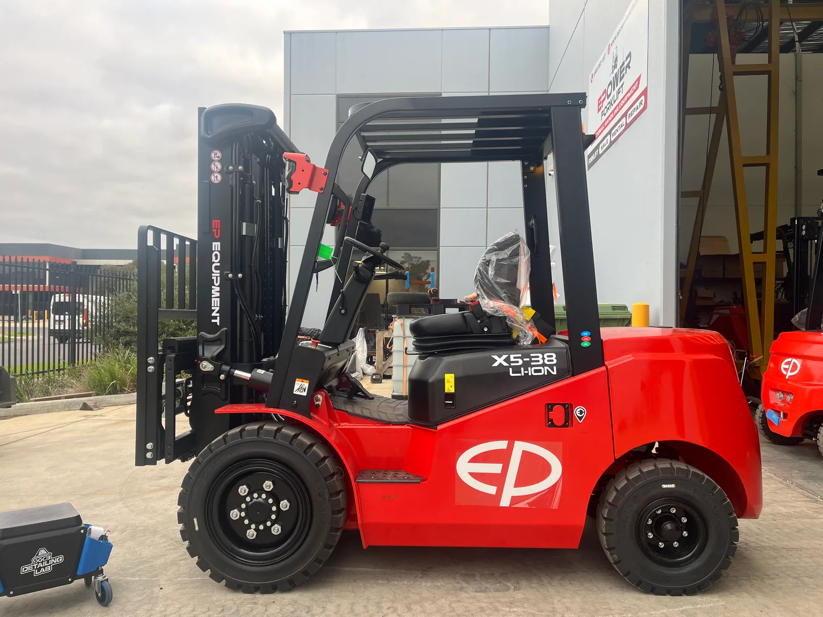 EP Equipment EFX5-381 3.8T lithium-ion electric forklift parked outside the EPower Forklift workshop, right side view