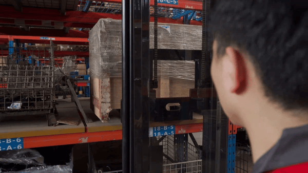 Operator’s upward view while stacking goods with EP Equipment ESA121-D electric walkie pallet stacker, highlighting clear mast visibility.