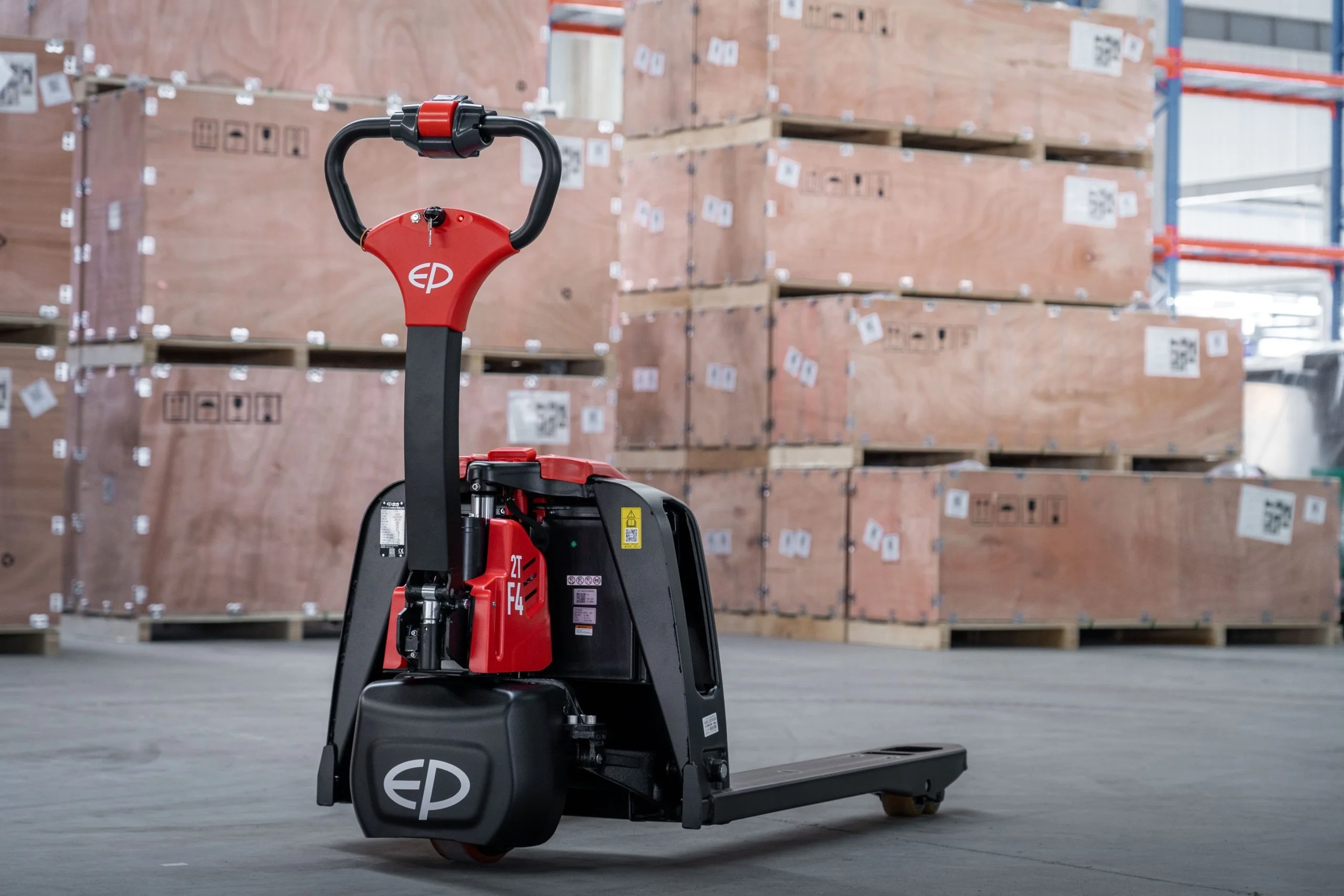 EP Equipment F4-201 electric pallet truck in warehouse with stacked wooden crates.