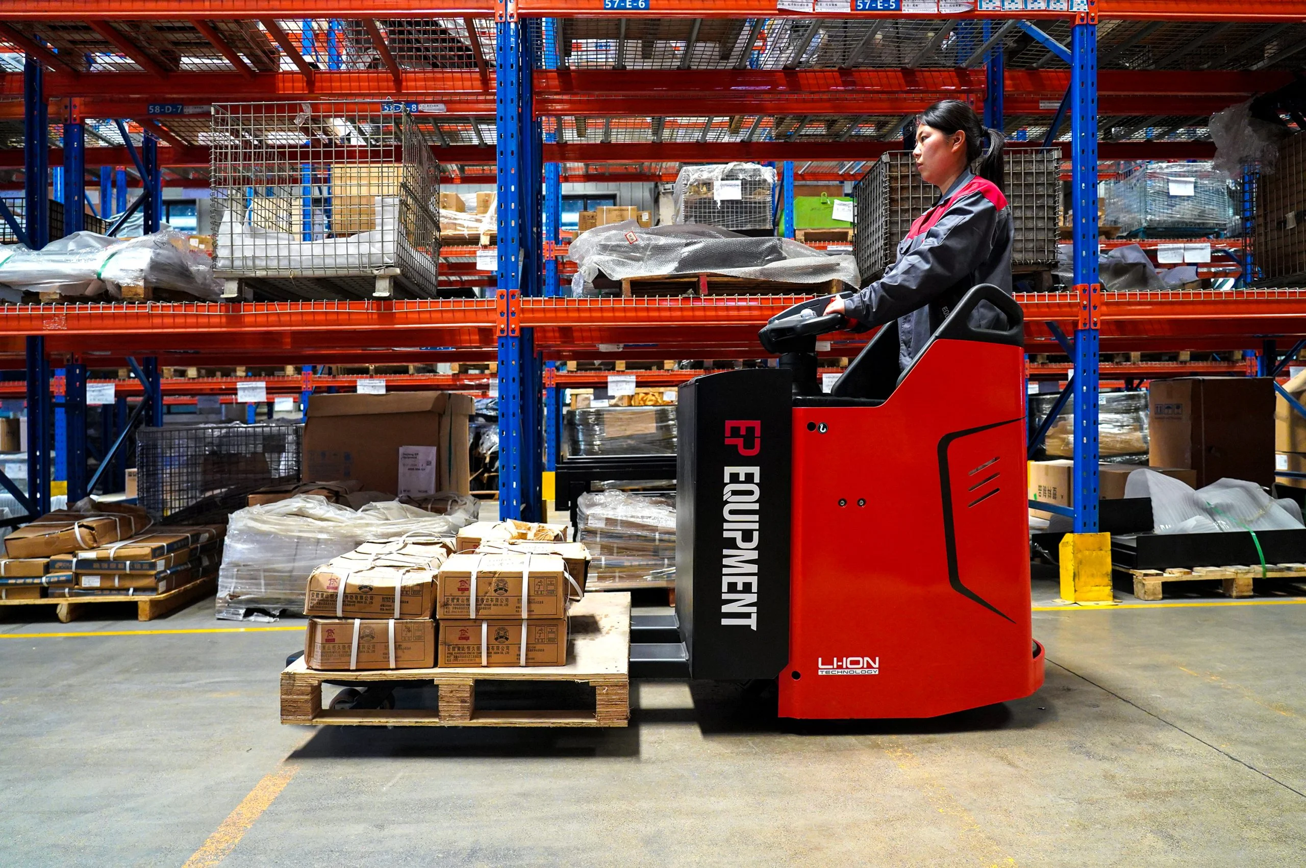 Operator driving EP Equipment KPL201 electric pallet truck to transport goods in warehouse.